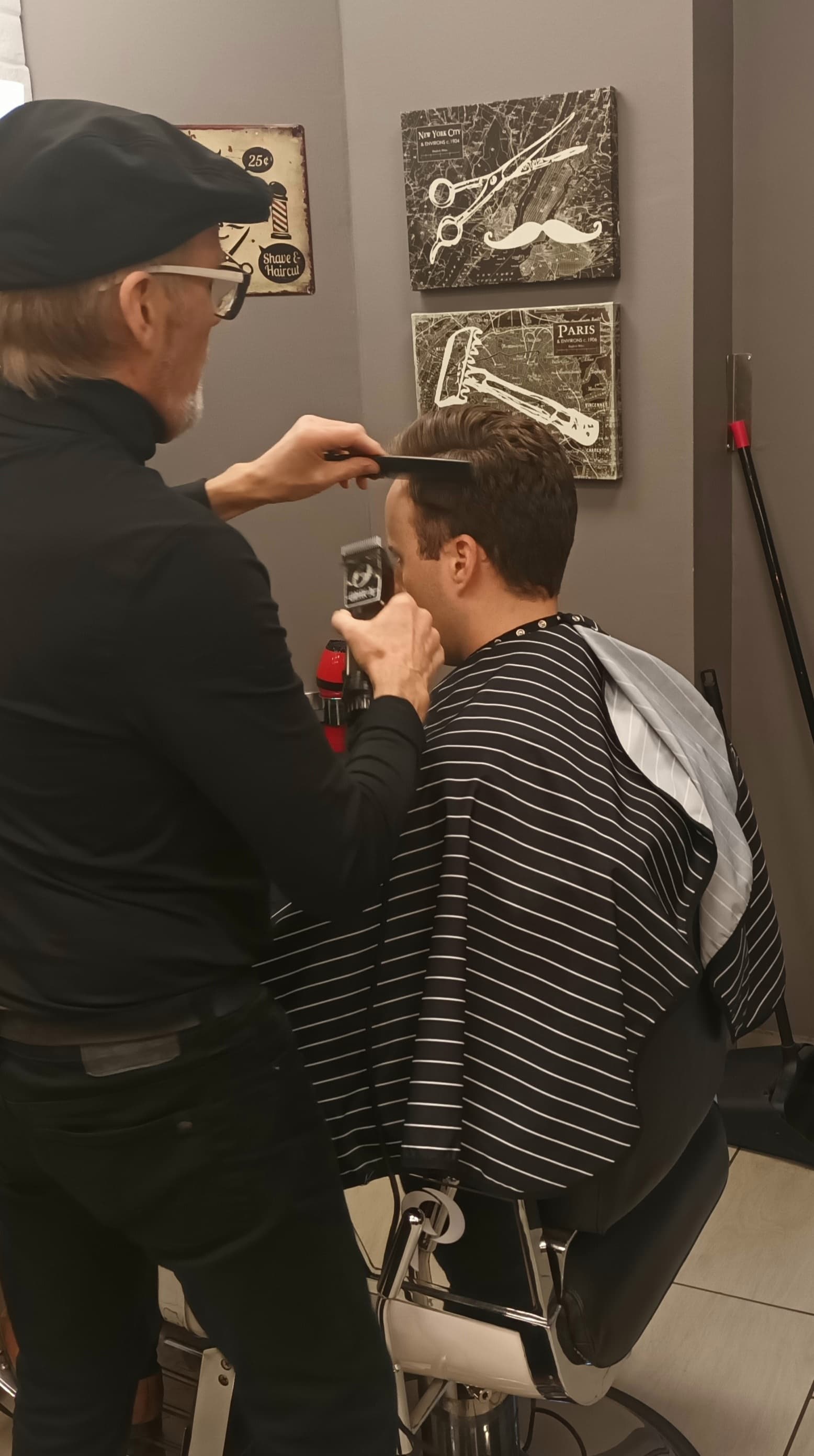 Barber using clippers on a client at Urban Philosophy barbershop Toronto