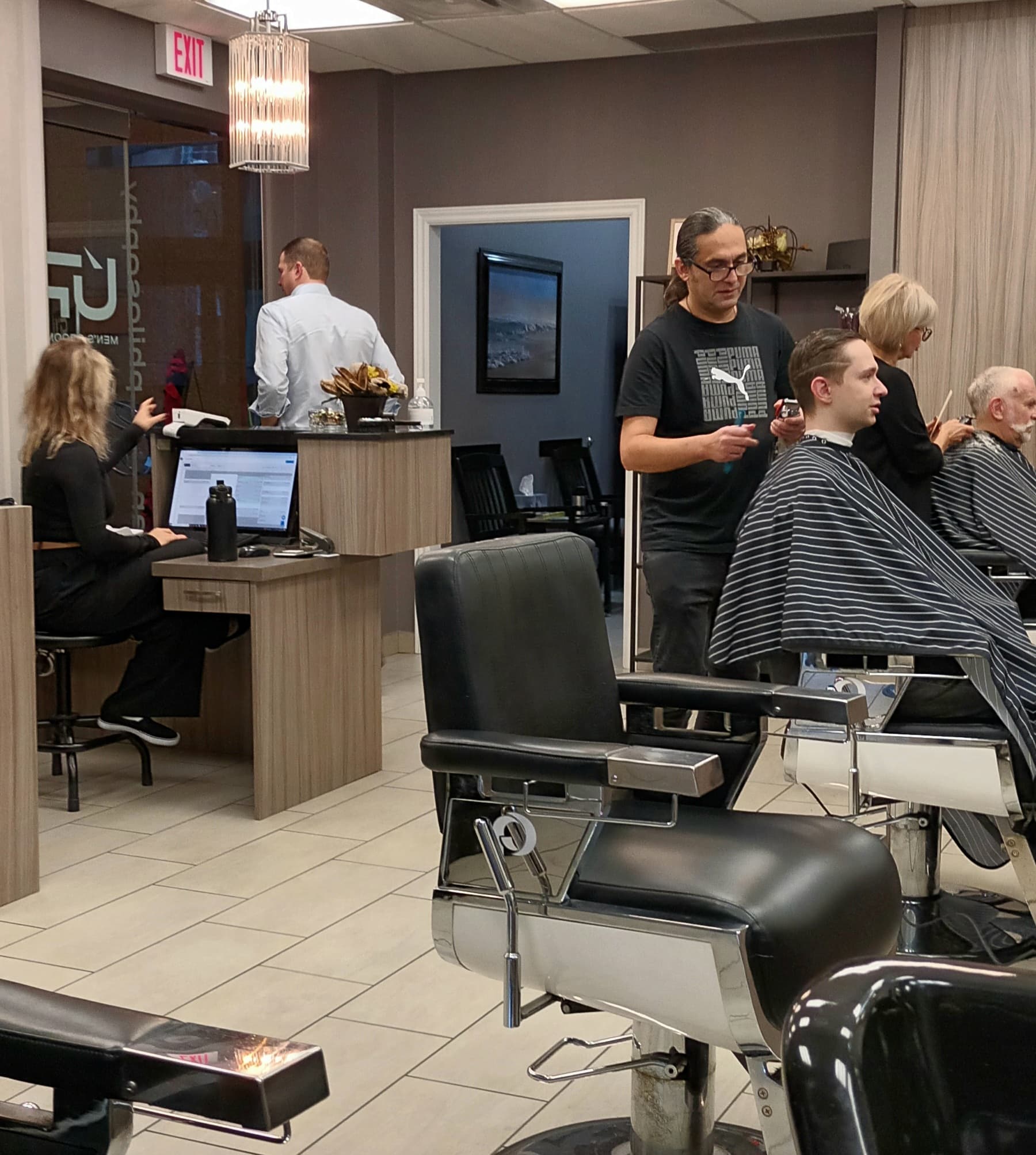 Barber cutting a client's hair at Urban Philosophy men's grooming in Toronto