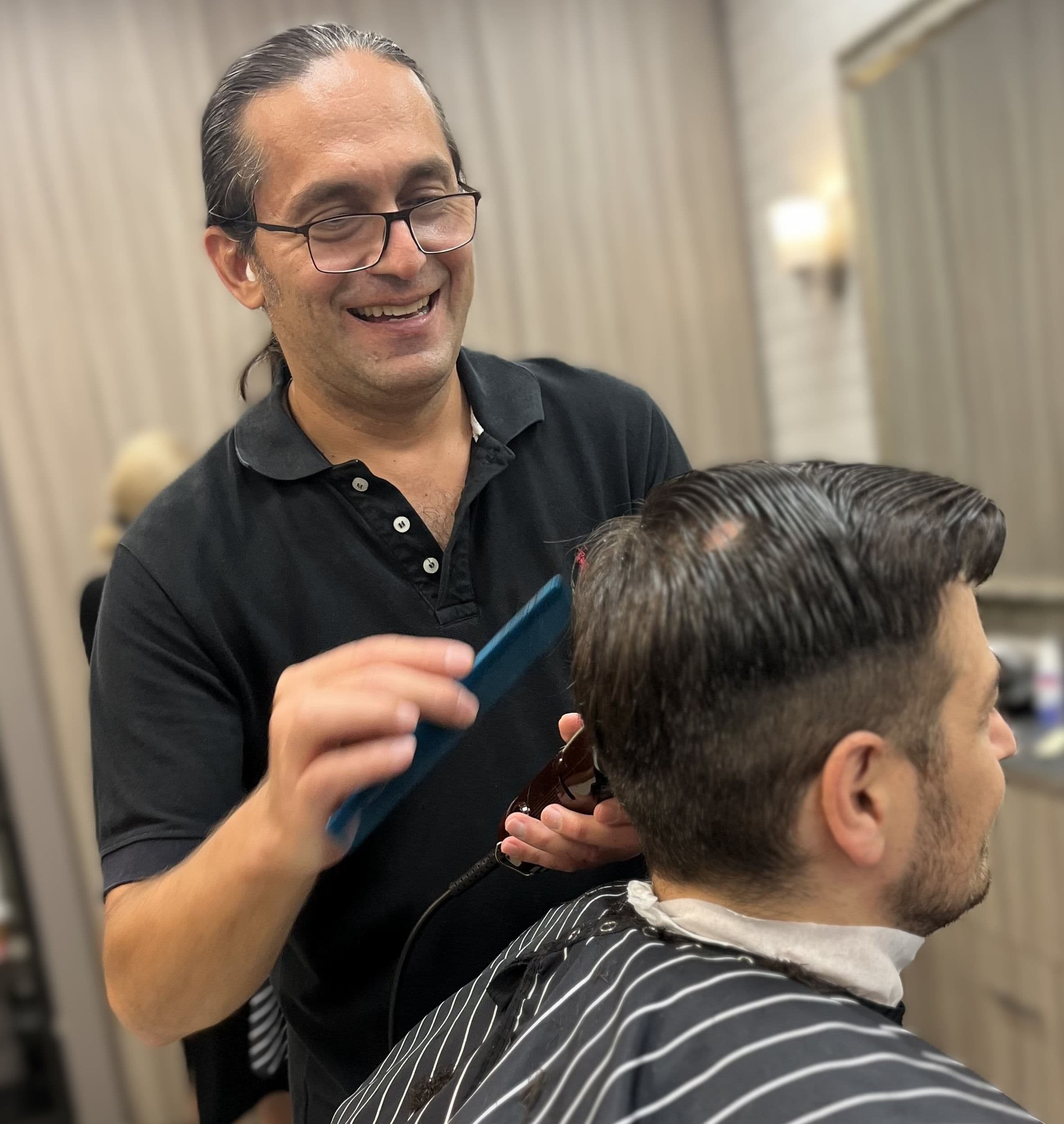 Reza, barber at Urban Philosophy performing a haircut in Toronto
